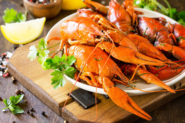 Boiled crawfish, lemon and parsley on a wooden table. Appetizer protein, the concept of healthy eating. Copy space.
