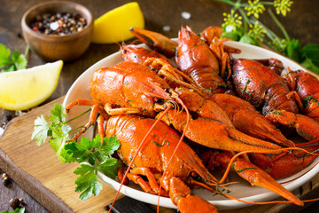 Boiled crawfish, lemon and parsley on a wooden table. Appetizer protein, the concept of healthy eating.
