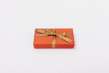 One rectangular red gift box with gold ribbon