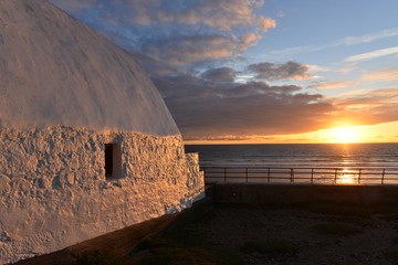 Don Hilton, St Ouen, Jersey, U.K.  Uninhabited 19th century croft by the sea at sunset. © alagz
