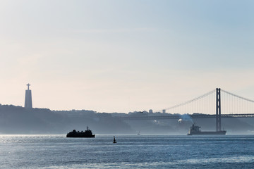 A city on the banks of the river Tagus and silhouette of the monument. ships on the waters of the river Tagus and the bridge that connects the two shores