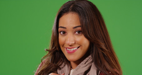 Close up of attractive Latina woman smiling warmly at camera on green screen