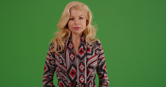 Blonde stylish white female looking at camera on green screen