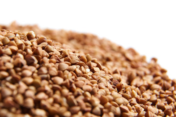 Obraz premium Heap of Buckwheat grains. Dry brown kernel on white background. Selective focus