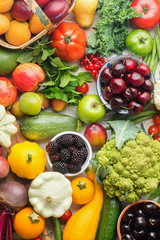 Healthy summer fruits vegetables berries background, cherries peaches strawberries cabbage broccoli cauliflower squash tomatoes carrots spring onions beans beetroot, pepper, top view, vertical
