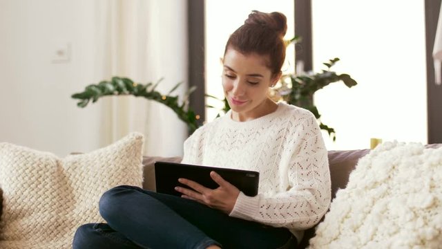 technology and people concept - smiling woman with tablet pc computer at home