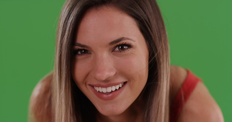 Close up of happy pretty millennial woman smiling at camera on green screen