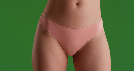 Close up portrait of young woman's hips and thighs on green screen