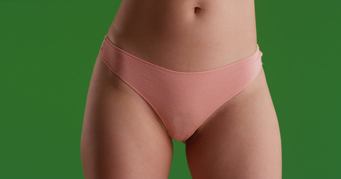 Close up portrait of young woman's hips and thighs on green screen