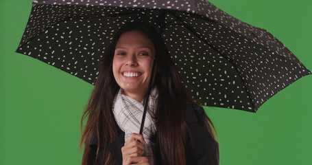Portrait of pretty woman posing with umbrella on green screen