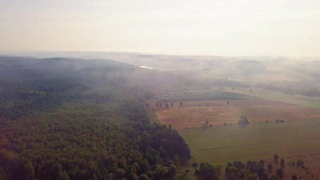 4j AERIAL: Flight over misty fields and forest at early autumn sunrise. Polish landscape. 3840x2160, 24fps.