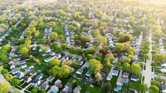 Aerial view of residential houses at spring (may). American neighborhood, suburb.  Real estate, drone shots, sunset, sunlight, from above.
