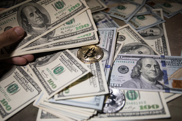 golden bitcoin coin on us dollars close up