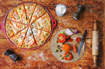 Freshly prepared hot pizza on a wooden table