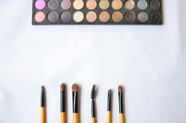 Cosmetic set of brushes and eye shadow on white background