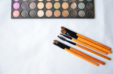 Cosmetic set of brushes and eye shadow on white background