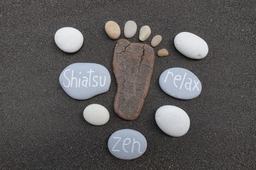 Shiatsu, Zen and Relax concept with stones over black volcanic sand