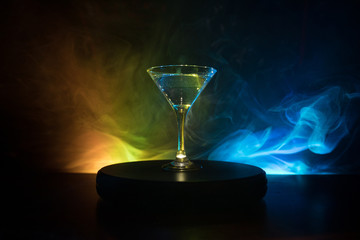 glass with martini with olive inside. Close up view of glass with club drink on dark foggy toned background. Club drink concept