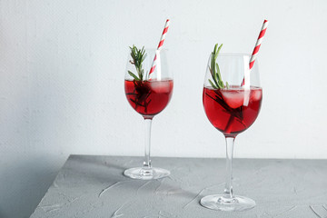 Tasty refreshing cranberry cocktail with rosemary on table