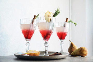 Tasty refreshing pear cocktail with rosemary on table