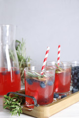 Tasty refreshing blueberry cocktail with rosemary on table