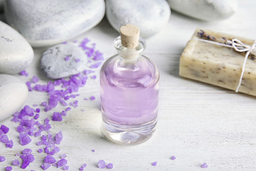 Obraz na płótnie Canvas Bottle with natural lavender oil and soap on wooden background