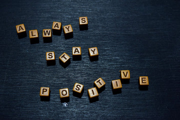 Fototapeta na wymiar Always stay positive message written on wooden blocks. Motivation concepts. Cross processed image