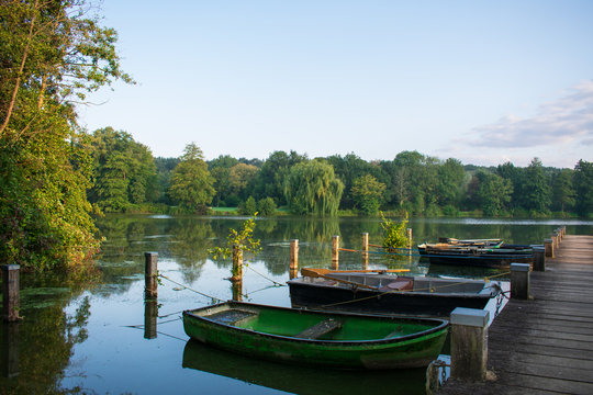 Lake with jetty and old rowboats. Location: Germany, North Rhine Westphalia, Hoxfeld