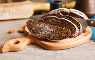 Freshly Baked Homemade Dark Bread with White Flour Sliced on Wooden Board. Close up. Copy space.