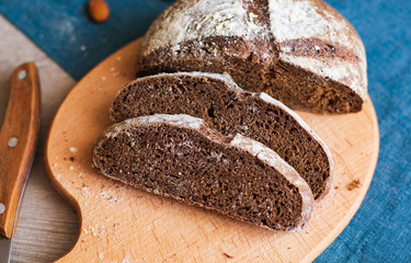 Freshly Baked Homemade Dark Bread with White Flour Sliced on Wooden Board. Close up. Copy space.