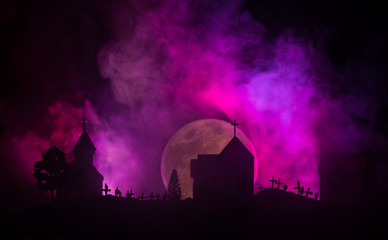 Scary view of zombies at cemetery dead tree, moon, church and spooky cloudy sky with fog, Horror...