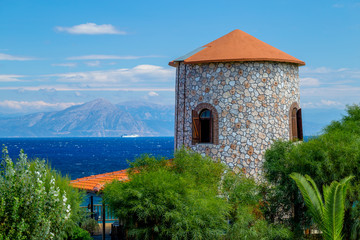 View of the Ancient Greek Windmill Tower and the Sea with Ship and Distant Coastline