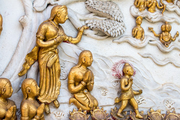 Fototapeta na wymiar Thai style cement carving art on temple wall in Wat Chai Mongkon - Buddhist Temple , Chiang Mai Thailand