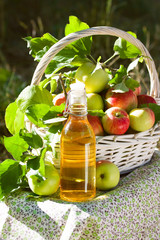 Basket with apples cider juice or vinegar in glass bottle