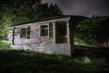 Fototapeta na wymiar Mountain night landscape of building at forest at night with moon or vintage country house at night with clouds and stars. Summer night.