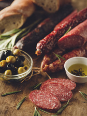 Sliced  Salami in rustic style. Salami sausage. Different sausages with olive