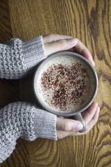A woman holding a cup of coffee, flat lay
