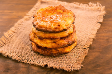 Four round cookies, stacked column on a napkin made of linen, close-up, wooden background.