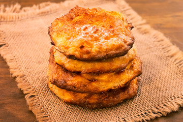 Curd cookies stacked on top of each other in a vertical column on a linen napkin, close-up.