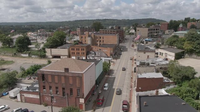 A summer slow forward aerial establishing shot of the main street in a small town in western Pennsylvania. Pittsburgh suburbs.  	