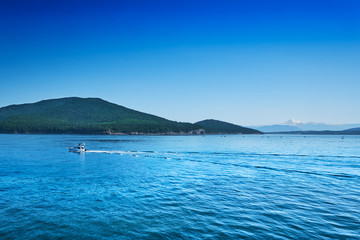 Fototapeta premium Summer weekend boaters enjoy calm seas and scenic views of Mt Baker in the San Juan Islands, Washington