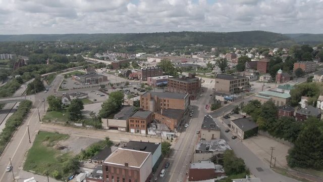 A summer slow forward high angle aerial establishing shot of the main street in a small town in western Pennsylvania. Pittsburgh suburbs.  	