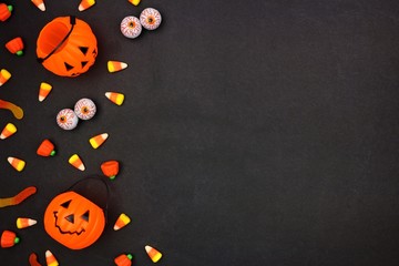 Halloween candy side border over a dark black background. Copy space.