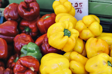 A pile of red, yellow and green bell peppers at the farmers market