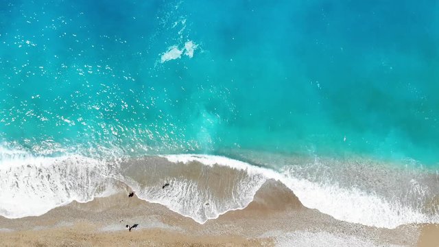 Aerial view of splashing sea waves and beach.
