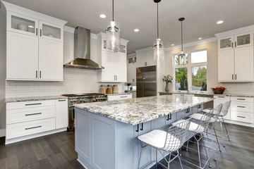 Beautiful kitchen in luxury home interior with island and stainless steel chairs