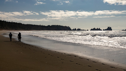 Two men back-packing along the surf in the Pacific Northwest