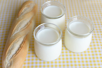 three jars with Greek yoghurt and a crispy French baguette