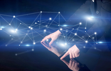 Male hands touching interactive table with blue connectivity graphic in the background