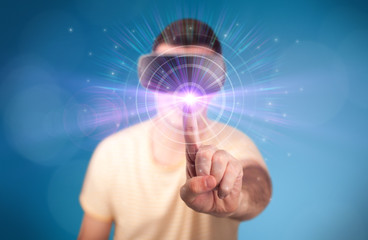 Young impressed man wearing virtual reality goggles with blue circles around his finger 